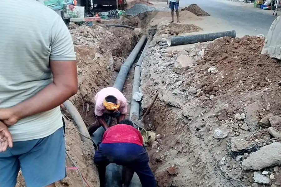 Workers laying transmission pipeline along the highway