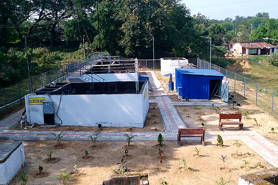 STP treatment tanks with walkway railing and equipment shed